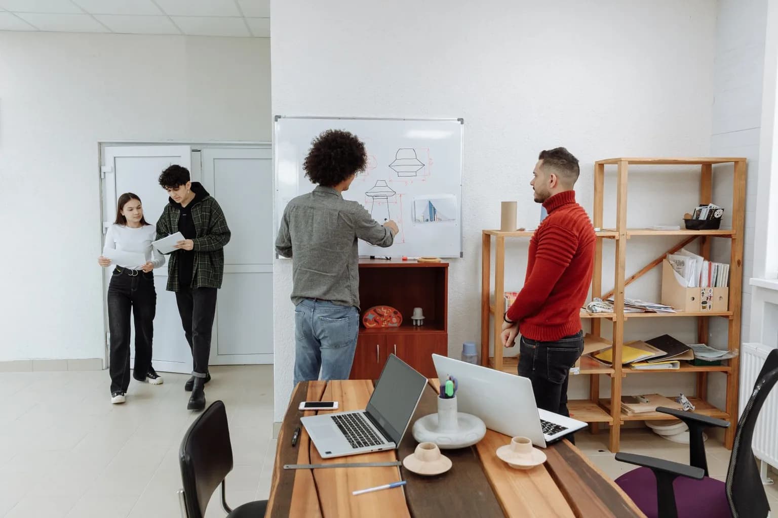 A product team mapping a data workflow on a whiteboard in a bright office