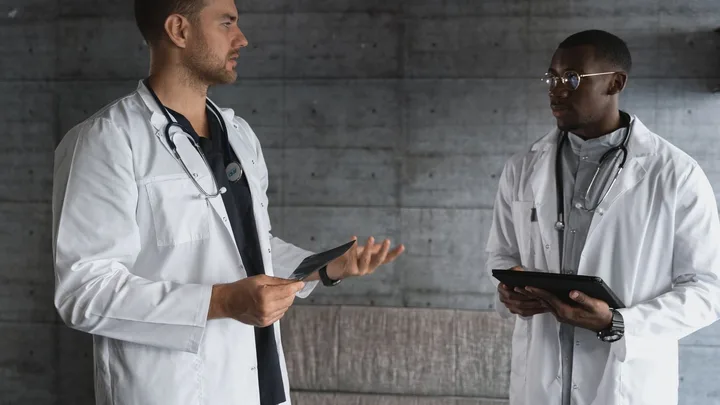 Two medical professionals discuss tablets during a focused healthcare work session